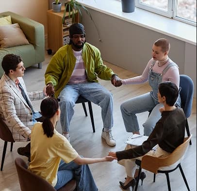 Personas participando en una conversación grupal de apoyo